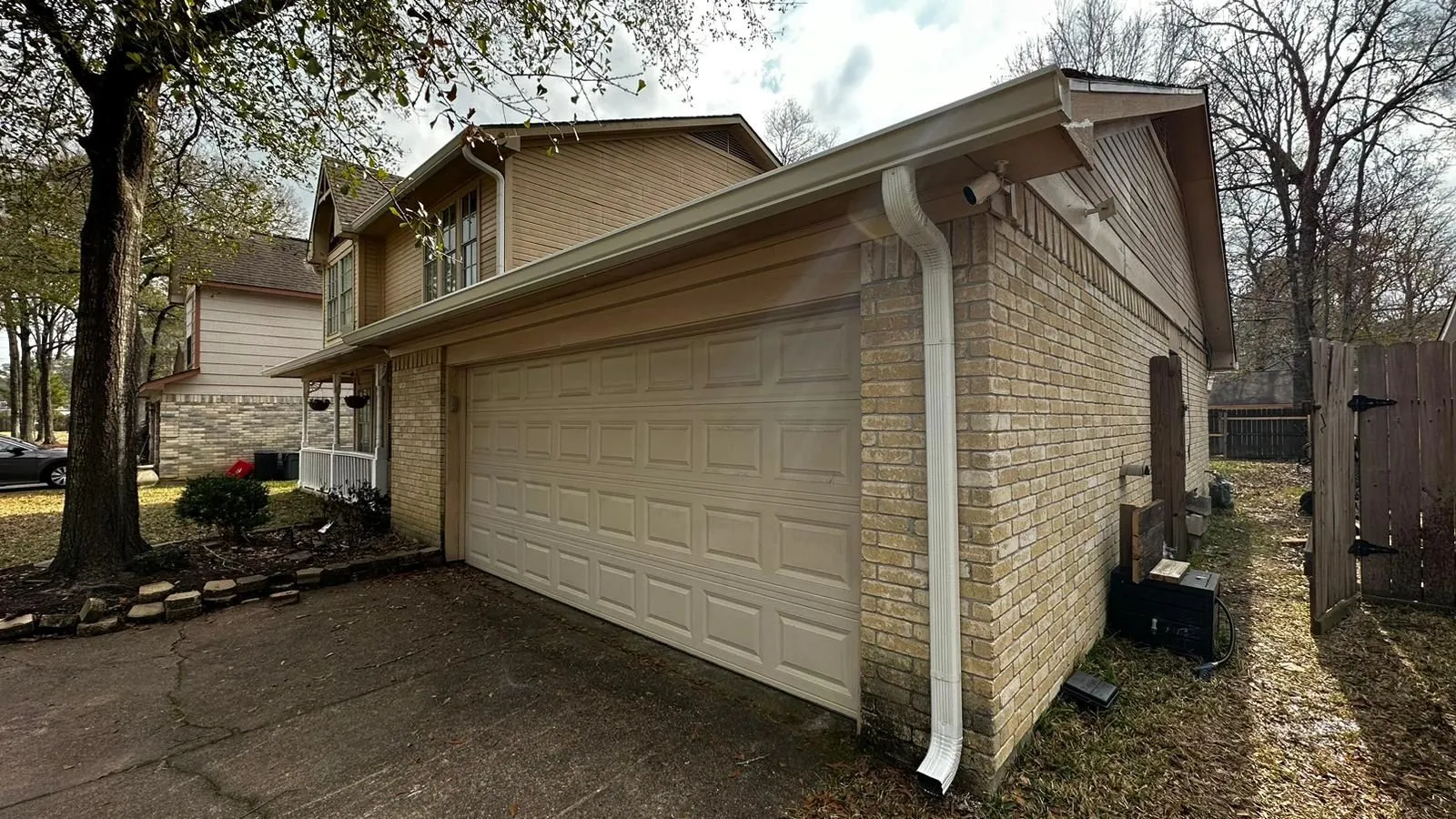Completed gutter installation on a Texas home showing clean downspout routing